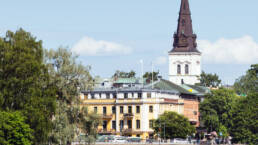 Karlstad sett från Älven med historiska byggnader och ett högt kyrktorn som reser sig över staden.
